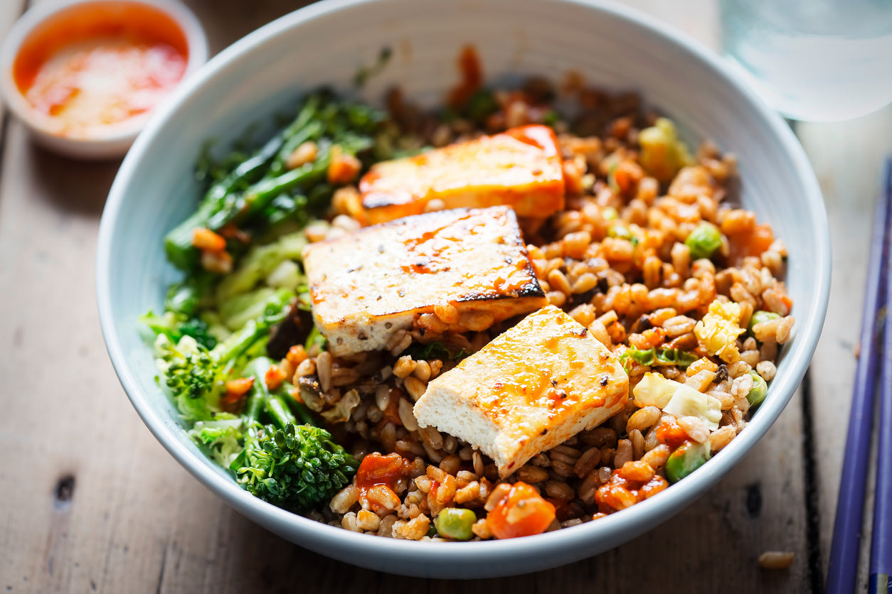 1 1/2 cup uncooked farro or brown rice 2 tablespoons vegetable oil 14 ounces extra firm tofu 2 cups asparagus, chopped 2 cups carrots, shredded 4 scallions, diced 3 cloves garlic, minced 2 inches fresh ginger, minced 2 tablespoons honey (more to taste) 2 